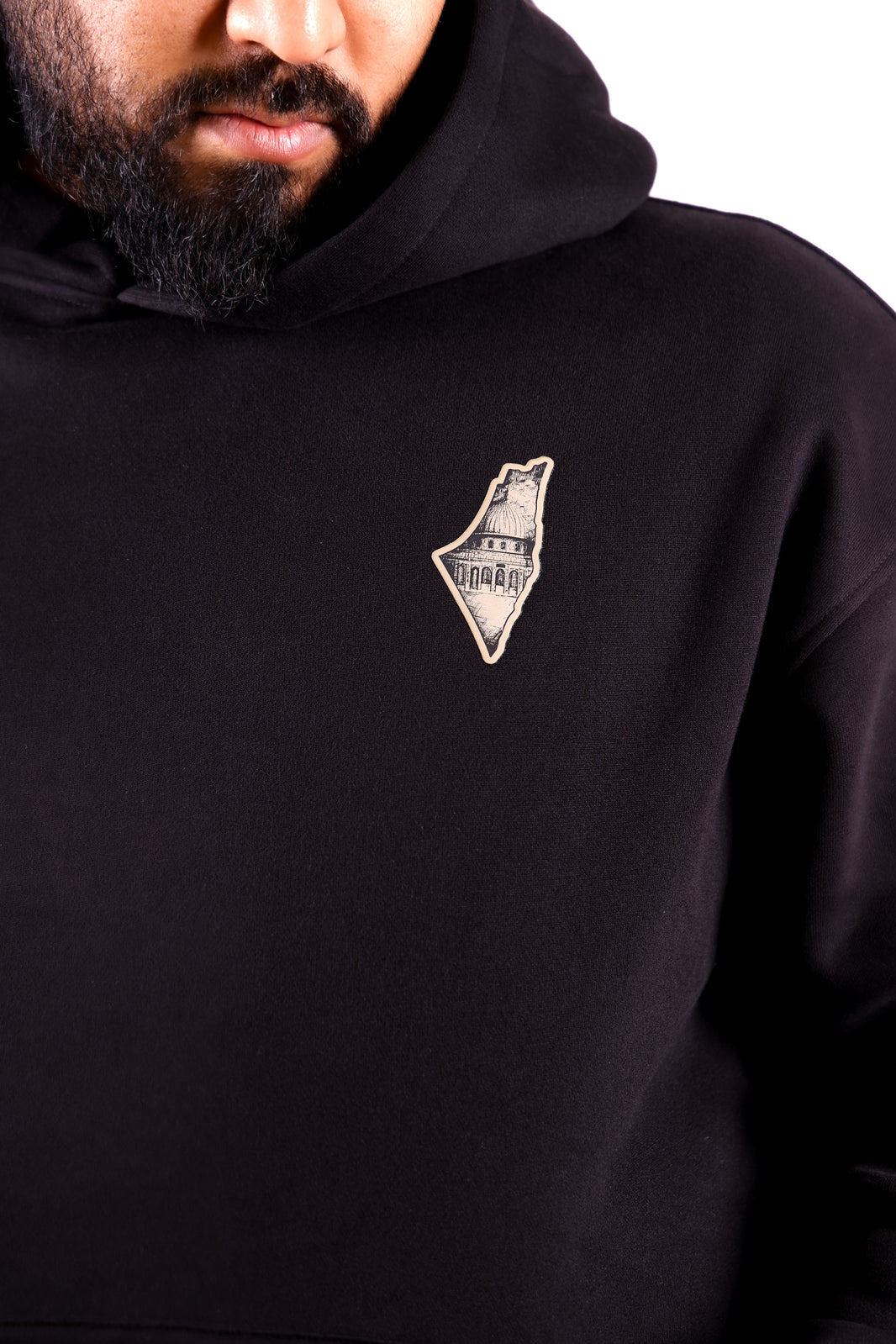 Black hoodie with a logo on the chest worn by a person