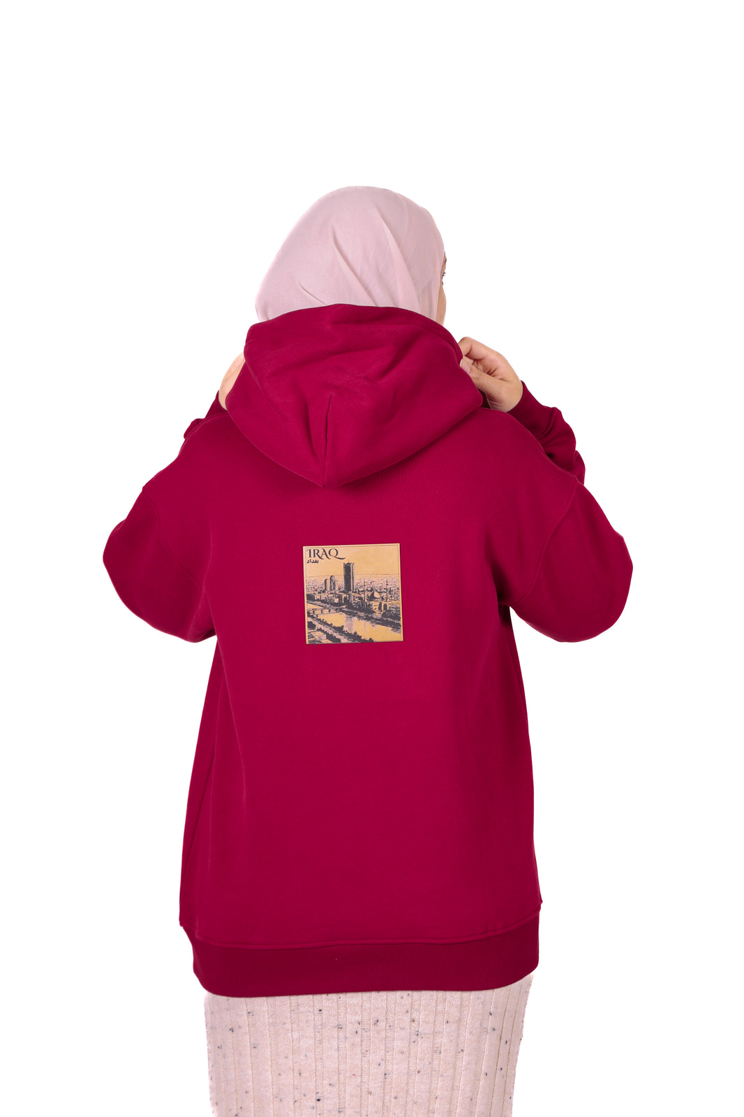 Person wearing a red hoodie with a graphic on the back, standing against a white background