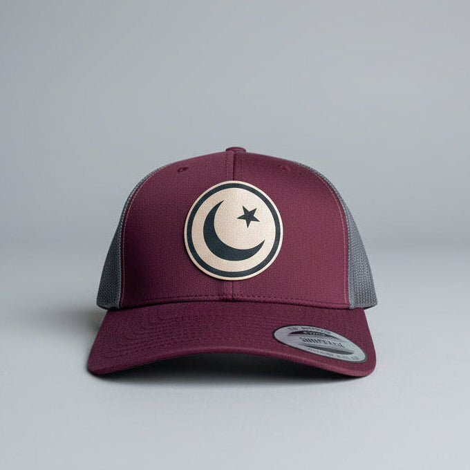 Maroon and gray cap with a circular emblem featuring a moon and star on a light gray background