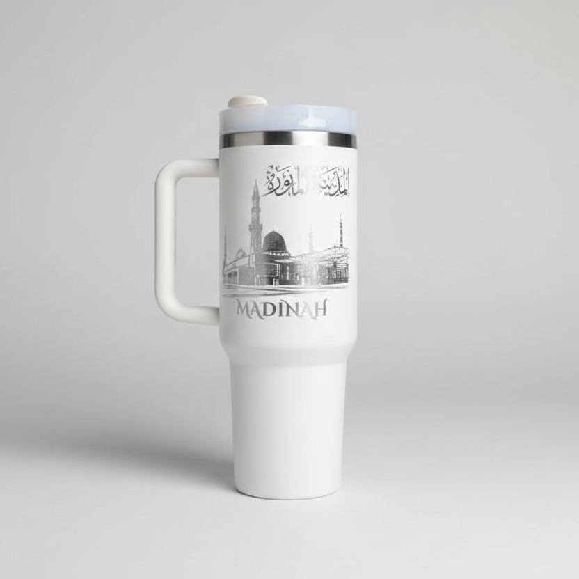White travel mug with 'Madinah' design on a light gray background